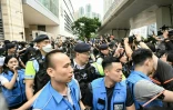 Des policiers tentent de contrôler le déploiement des journalistes devant un tribunal de Hong Kong avant une audience qui a déclaré 14 militants pro-démocratie coupables de "subversion" le 30 mai 2024