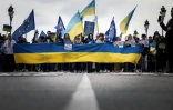 Des manifestants agitent des drapeaux ukrainiens et européens à Toulouse lors d'une manifestation contre l'invasion russe de l'Ukraine le 6 mars 2022.
