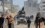 Des Palestiniens déplacés transportent leurs affaires sur une jeep dans une rue de Khan Younès, dans le sud de la bande de Gaza, le 6 mars 2024