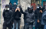 Des protestataires lancent des pierres contre la police anti-émeutes le 4 juin 2016 à Paris pendant une marche des "antifascistes" à la mémoire du militant d'extrême gauche Clément Méric