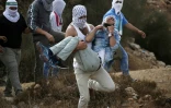 Un jeune palestinien est évacué par ses camarades après avoir été touché lors d'affrontements avec la police israélienne à Beit El (Cisjordanie), le 10 octobre 2015