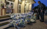 Des personnes déposent des fleurs le 16 octobre 2023 devant la cité scolaire Gambetta-Carnot d'Arras en hommage au professeur Dominique Bernard assassiné trois jours plus tôt