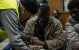Un migrant montre à un infirmier bénévole les engelures de ses mains après sa tentative de franchir la frontière franco-italienne, le 13 janvier 2018 à Bardonecchia