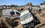 Des Palestiniens inspectent les dégâts dans un chantier de réparation d'ambulances touché par des frappes israéliennes dans le camp de réfugiés d'al-Maghazi, dans le centre de la bande de Gaza, le 24 mars 2025