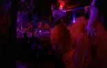 La manager Valérya Zavatska (g), diplômée en droit, et sa mère, ancienne danseuse, regardent les danseuses lors d'une représentation au club de strip-tease "Flash Dancers", le 15 mai 2025 à Kharkiv, en Ukraine
