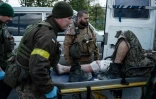 Des soldats ukrainiens évacuent un blessé près de Lyssytchansk, proche du front de l'est ukrainien, le 10 mai 2022