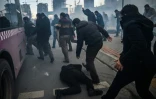Un homme aide un manifestant tombé par terre, alors que la police anti-émeutes turque fait usage de gaz lacrymogènes pour disperser une manifestation de soutien au quotidien Zaman, le 5 mars 2016 à Istanbul