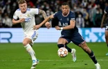 L'attaquant du Paris Saint-Germain Kylian Mbappé déborde le milieu de terrain allemand du Real Madrid Toni Kroos, lors du quart de finale retour de la Ligue des Champions, le 9 mars 2022 au Stade Santiago Bernabeu 