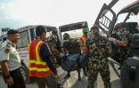 Sur cette photo prise le 16 mai 2024 et diffusée par l'armée népalaise, des soldats chargent des corps congelés récupérés sur l'Everest dans une ambulance en vu de leur incinération à l'aéroport international de Tribhuvan à Katmandou