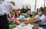 Des bénévoles distribuent de la nourriture et des produits de première nécessité à Caraballeda, dans l'État de La Guaira, le 30 juin 2026 au Venezuela