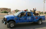 Des policiers irakiens font le signe de la victoire en patrouillant dans les environs de Kirkouk, le 25 octobre 2016