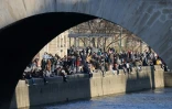 Des personnes se rassemblent le long de la Seine pour profiter d'un après-midi ensoleillé, à Paris, le 28 février 2021