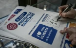 Un patron de commerce prépare une affiche du protocole sanitaire à respecter pour la réouverture le 28 novembre 2020 des commerces non essentiels, le 25 novembre 2020 à Bordeaux