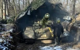 Un soldat ukrainien de la 3e brigade de chars des forces terrestres ukrainiennes camoufle un char T-72 dans un lieu tenu secret dans la région de Kharkiv, le 10 février 2025
