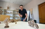 Le PDG Oleksiï Lyssiany montre les différents modèles de maquettes en bois produites par l'usine Ugears, le 6 juin 2022 à Gorenka, au nord de Kiev, en Ukraine