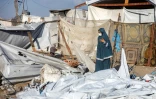 Un femme observe le site d'une frappe israélienne dans un camp de déplacés à al-Mawasi, dans le sud de la bande de Gaza, le 5 août 2025
