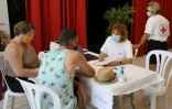 Une membre de la Croix-Rouge française accueille des vacanciers venus de faire vacciner contre le Covid-19, le 13 août 2021 dans un camping d'Argelès-sur-Mer