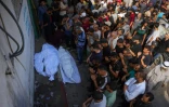 Des Palestiniens rassemblés autour des corps de leurs proches tués la veille en attendant de l'aide humanitaire, le 31 juillet 2025 à l'hôpital al-Chifa, dans le nord de la bande de Gaza