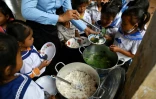 Des écoliers prennent un petit-déjeuner avant d'entrer en classe, le 8 juillet 2022 dans la province de Siem Reap, au Cambodge