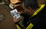 Yasser Nabhan regarde son album de photos dans son logement à Alep, le 11 mars 2016