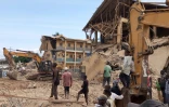 Des passants devant l'école qui s'est effondrée à Jos, au Nigeria, le 12 juillet 2024