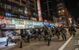 Des policiers courent vers des manifestants à Hong Kong le 1er décembre 2019 