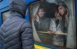 Une famille à bord d'un train d'évacuation fait ses adieux à un jeune homme resté sur place, le 6 mars 2022 en gare d'Odessa, dans le sud de l'Ukraine