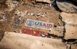 Un logo de l'Usaid sur un carton au milieu de restes éparpillés de boîtes et de matériaux abandonnés après des actes de vandalisme et de pillages à l'entrepôt du Programme alimentaire mondial (PAM) à Bukavu, le 21 février 2025 en RDC