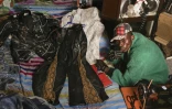 Le créateur de mode Morgan Azedy et quelques-unes de ses créations fabriquées à partir de tissus récupérés sur des marchés de vêtements d'occasion et des décharges, dans son atelier de Nairobi, le 6 octobre 2025 au Kenya