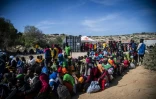 Des migrants attendent devant le centre d'accueil de Lampedusa, le 14 septembre 2023 en Italie
