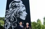 Emmanuel Macron et l'artsite de steet art Yseult Digan, qui signe YZ, posent devant une fresque de Marianne sur la façade d'un HLM à Périgueux, le 19 juillet 2018