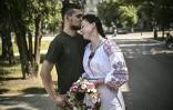 Un couple de militaires ukrainiens, Kristina et Vitali Orlich, pendant leur mariage dans la ville de Droujkivka, dans l'est de l'Ukraine, le 12 juin 2022