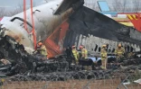 Les secours travaillent sur la carlingue du Boeing 737-800 sur les lieux du crash à l'aéroport de Muan, en Corée du Sud, le 30 décembre 2024