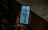 Josephine Ngoya, la mère d'Erastus Mundia, montre une photo de son fils, chez elle à Nabemo au Kenya, le 27 février 2026