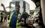 Une des conductrices de la société de transport ghanéenne Ladybird Logistics vérifie le niveau d'huile de son camion, le 3 avril 2019 au siège de la compagnie à Takoradi, au Ghana