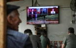 Des hommes regardent l'annonce de la dissolution du PKK sur un écran de TV à Diyarbakir, en Turquie, le 12 mai 2025