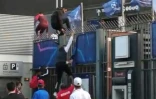 Des personnes sans billets escaladent les grilles du Stade de France pour assister à la finale de la ligue des Champions entre le Real Madrid et Liverpool, le 28 mai 2022 à Saint-Denis, au nord de Paris 
