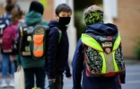 Des enfants font la queue en respectant une distance de sécurité entre eux, à l'école élémentaire Petri à Dortmund, en Allemagne, le 7 mai 2020