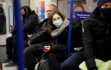 Des passagers, certains masqués d'autres non, dans le métro de Londres le 28 novembre 2021