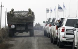 File de voitures d'observateurs de l'OSCE en charge de vérifier le rtrait des forces ukrainiennes près du village de Bogdanivka, dans la région de Donetsk, le 9 novembre 2019