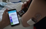 Un patient diabétique regarde sur un téléphone une application qui calcule automatiquement la bonne dose d'insuline, dans le cadre d'un essai au centre hospitalier de Strasbourg le 8 juin 2016
