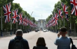Curieux prenant des photos sur l'avenue The Mall à Londres, menant au palais de Buckingham, le 26 mai 2022