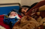 Une mère se repose près de son bébé à la clinique de Tangi Saidan,  le 6 octobre 2021 dans le centre de l'Afghanistan