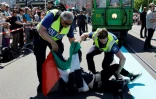 Des policiers bloquent un manifestant arborant un drapeau palestinien lors de la parade de l'Eurovision à Bâle, le 11 mai 2025 en Suisse