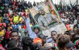Un partisan de l'opposant kényan Raila Odinga brandit une pancarte alors que la foule investit le stade où sa dépouille doit être exposée, à Kisumu, dans l'ouest du Kenya, le 18 octobre 2025