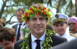 Le président Emmanuel Macron, une couronne de fleurs sur la tête, lors d'une cérémonie de bienvenue à Ouvéa, le 5 mai 2018 en Nouvelle-Calédonie