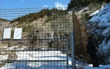 Un homme regarde à travers les barrières "sanctuarisant" le site du crash près du Vernet (Alpes-de-Haute-Provence), le 18 mars 2016
