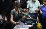 Une femme, son enfant dans les bras, vote pour les élections régionales espagnoles à Barcelone, le 27 septembre 2015