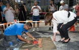 Vince Godinez (G), le fabricant de l'étoile et Ana Martinez (D), productrice du "Walk of Fame" préparent l'étoile de Charles Aznavour le 21 août 2017 à Hollyood en Californie