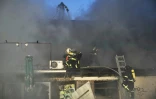 Des pompiers ukrainiens éteignent un incendie dans un bâtiement après une attaque de drones russes à Kiev, le 7 novembre 2024